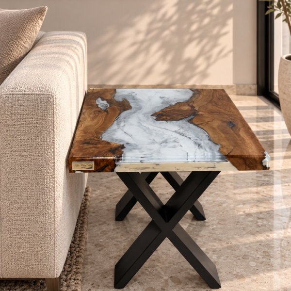 An olive wood side table with a marble-effect resin top beside a couch in a well-lit living room.