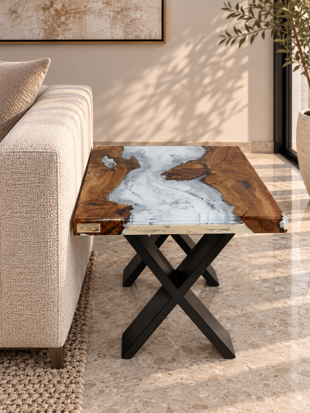 An olive wood side table with a marble-effect resin top beside a couch in a well-lit living room.