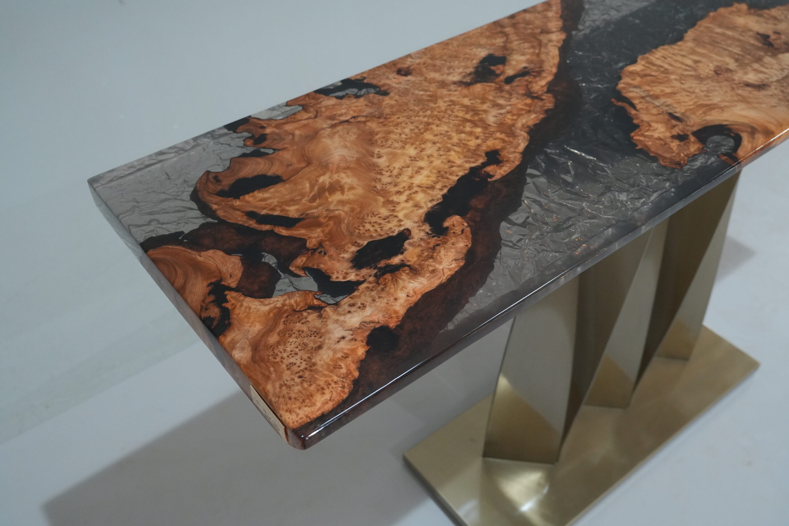 A close-up view of the Midnight Ice Console, showcasing its fir burl top and semi-translucent black epoxy finish.