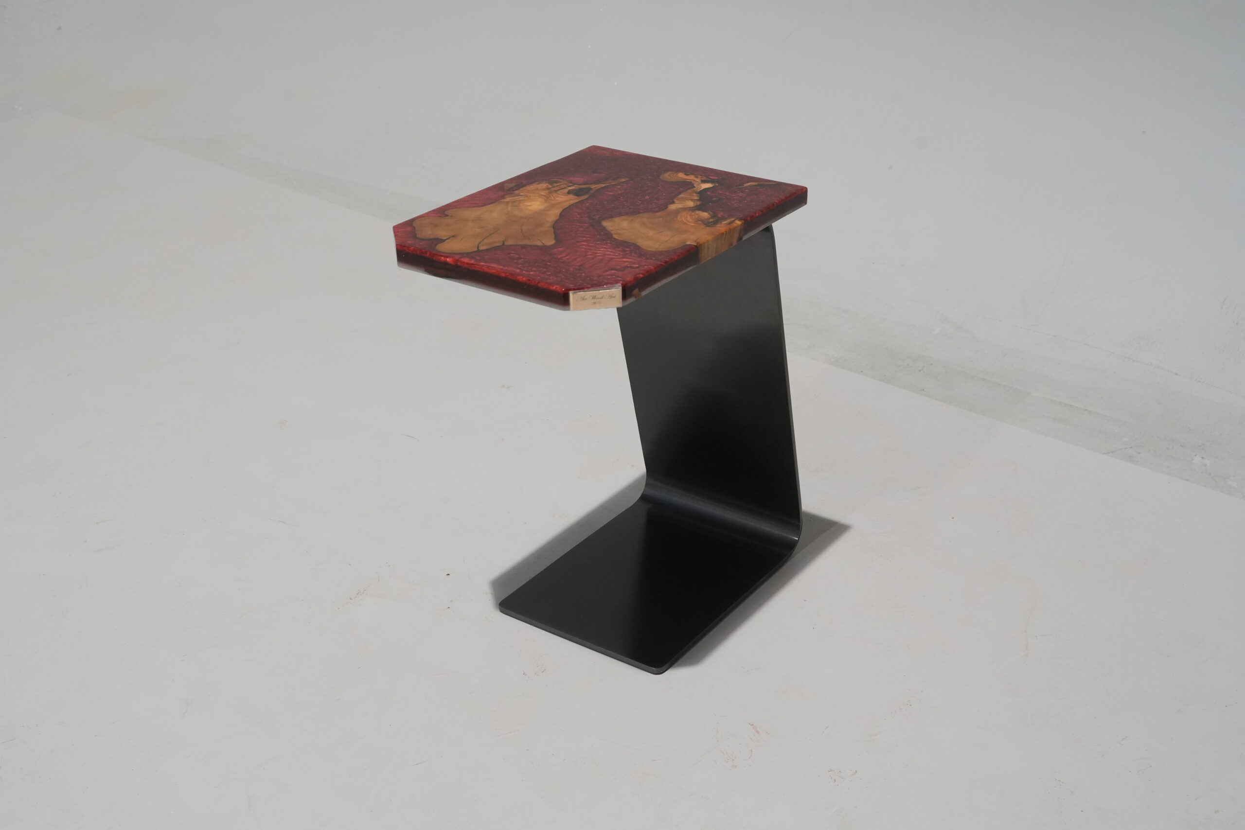 Side view of the sculptural base of the Crimson Olive Root Side Table showcasing its unique form.