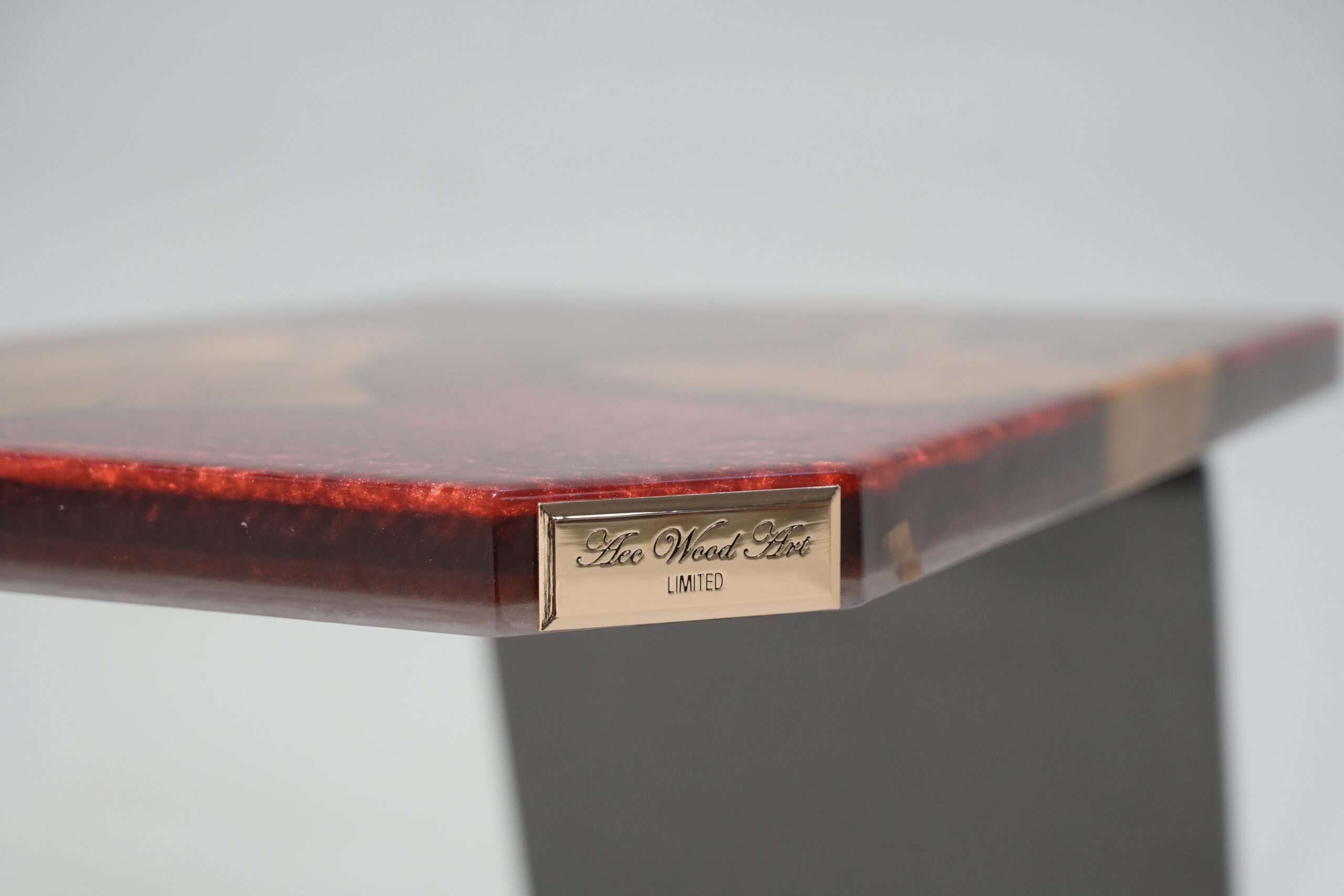 A close-up showing the branding plate on the edge of the Crimson Olive Root Side Table.