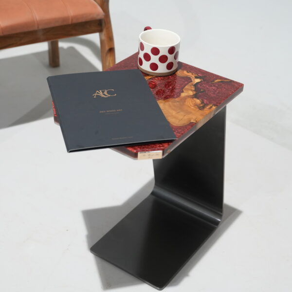 A close-up of the Crimson Olive Root Side Table showing the olive wood and crimson epoxy surface with a metallic finish.