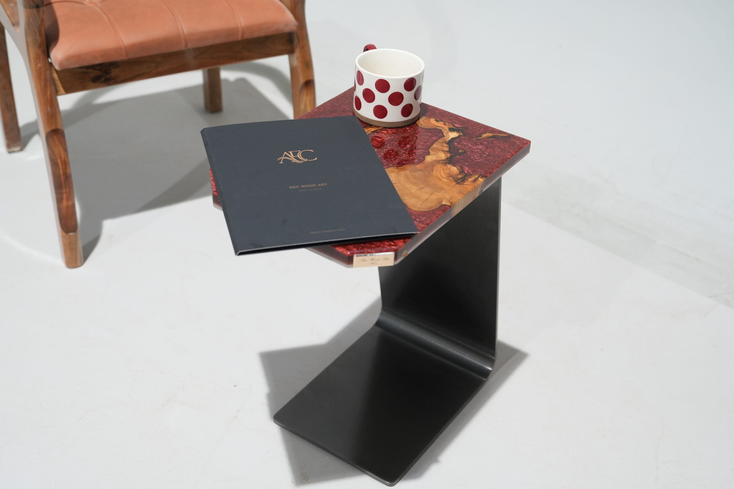 A close-up of the Crimson Olive Root Side Table showing the olive wood and crimson epoxy surface with a metallic finish.