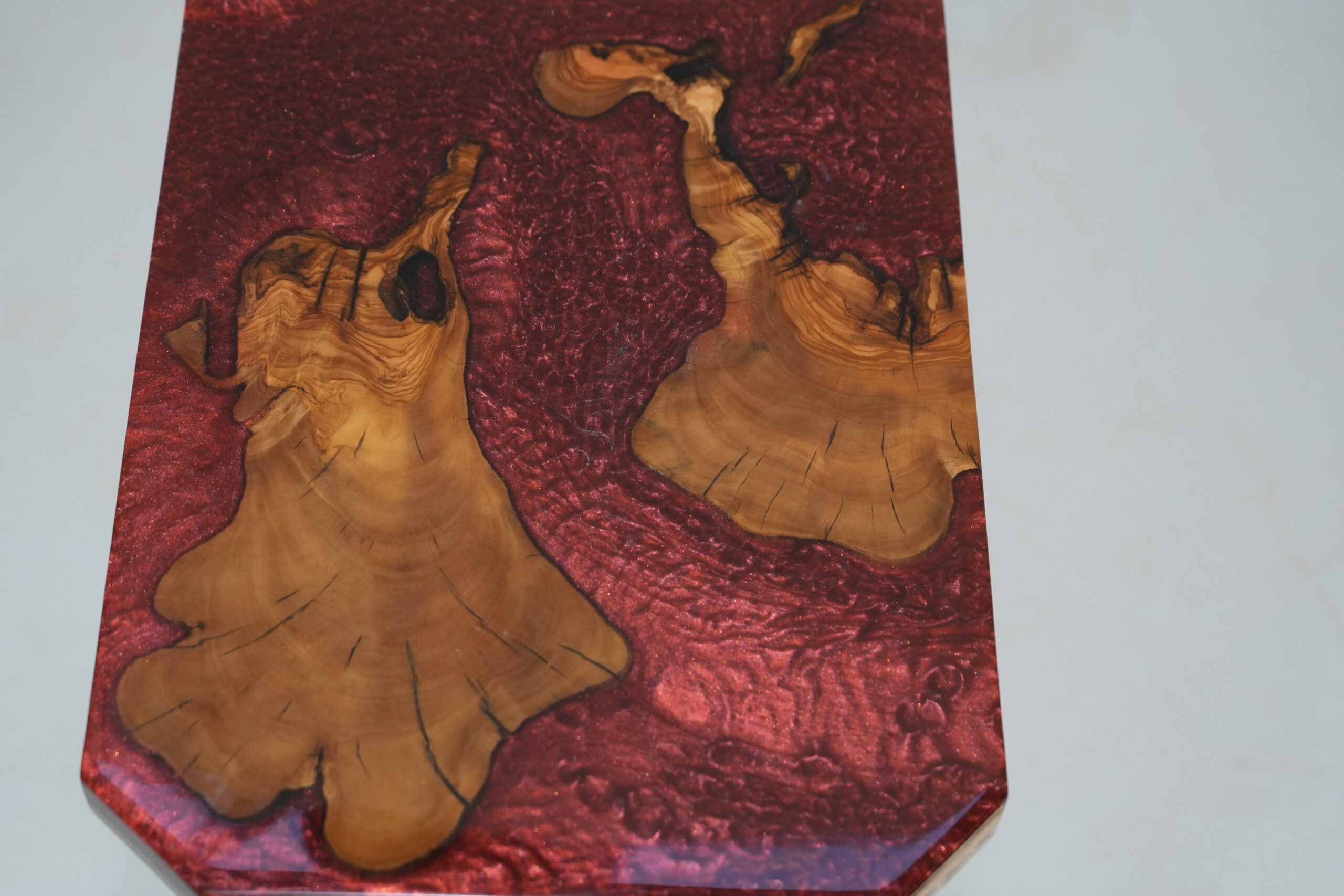 Another angle of the top of the Crimson Olive Root Side Table revealing the unique wood pattern and epoxy blend.