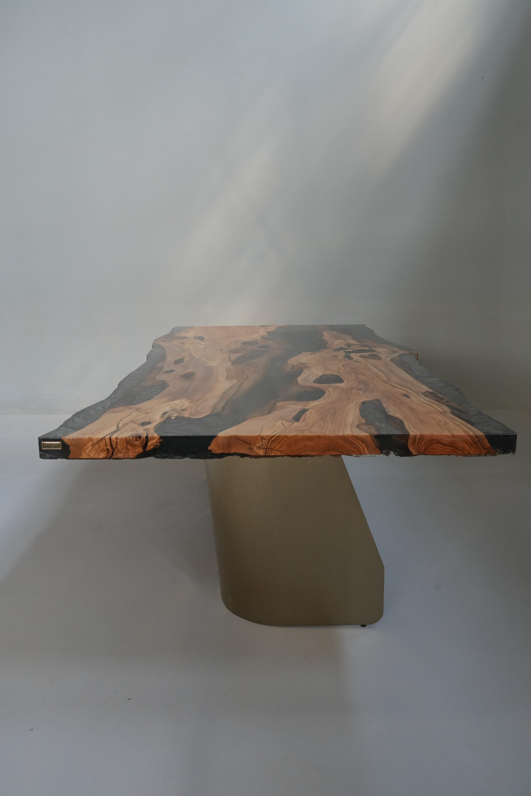 A close-up view of the Crystal Black Olive Dining Table showing the olive wood and crystalline black epoxy finish.