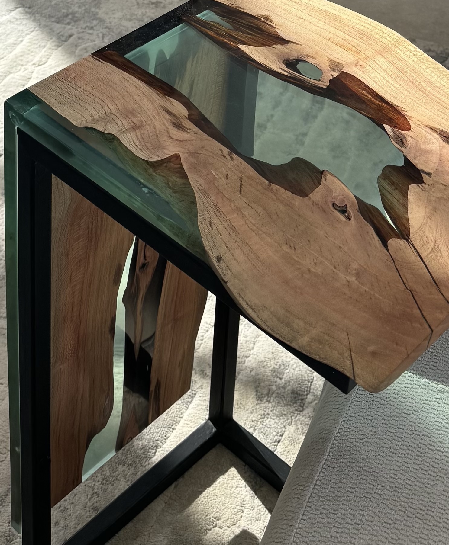 Close-up of the polished surface of the carob wood side table, showcasing the grain and the lime-green epoxy detail.